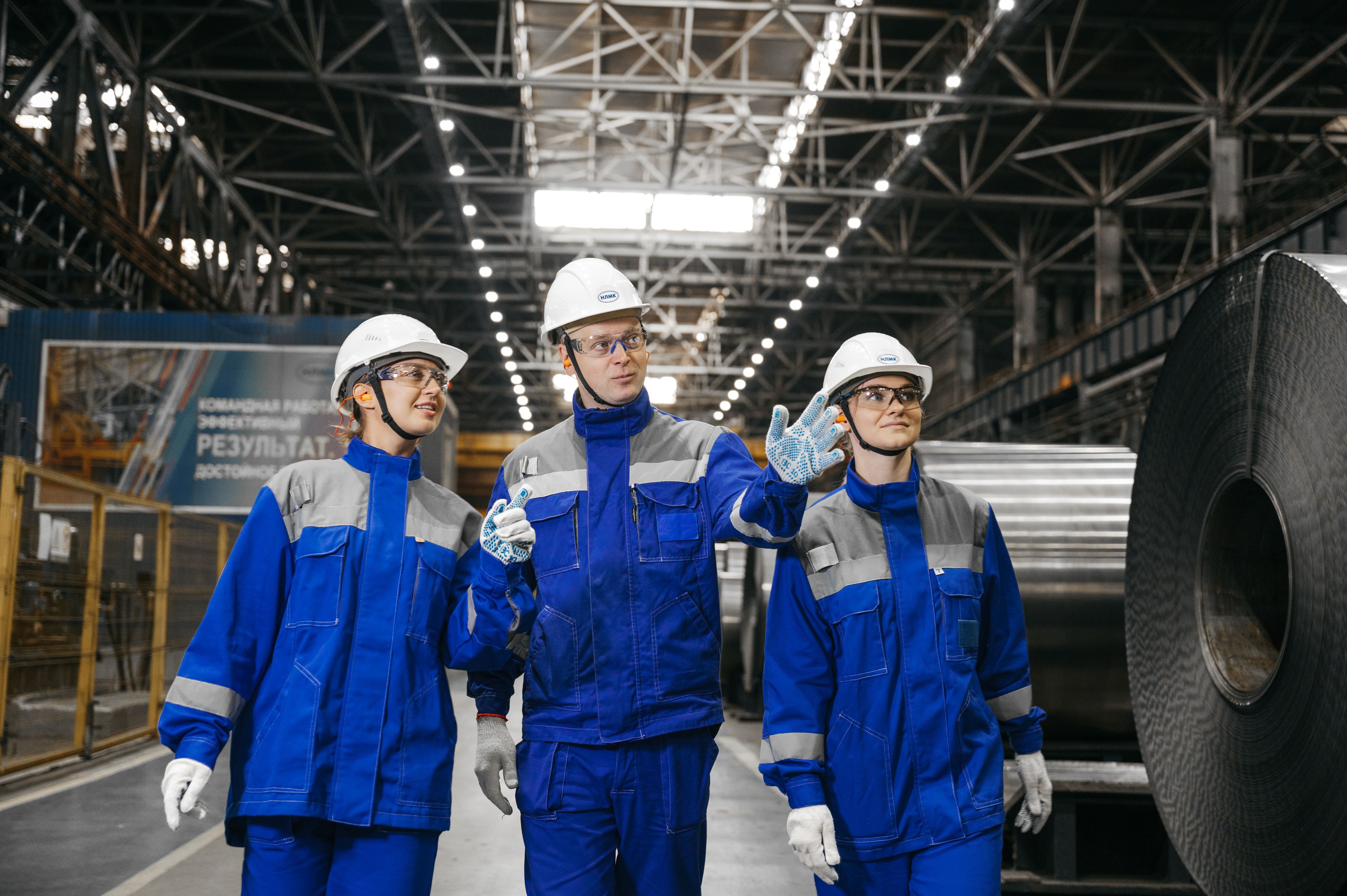 Profissionais trabalhando em ambiente industrial com equipamentos de proteção